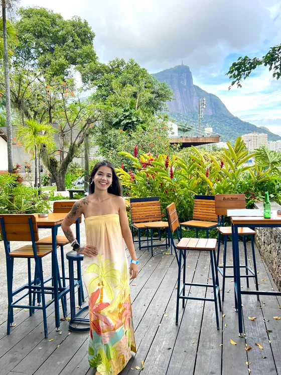 Anne Caroline on the garden terrace at the Jockey Club in Gávea, Rio de Janeiro, with Cristo Redentor on Corcovado behind her